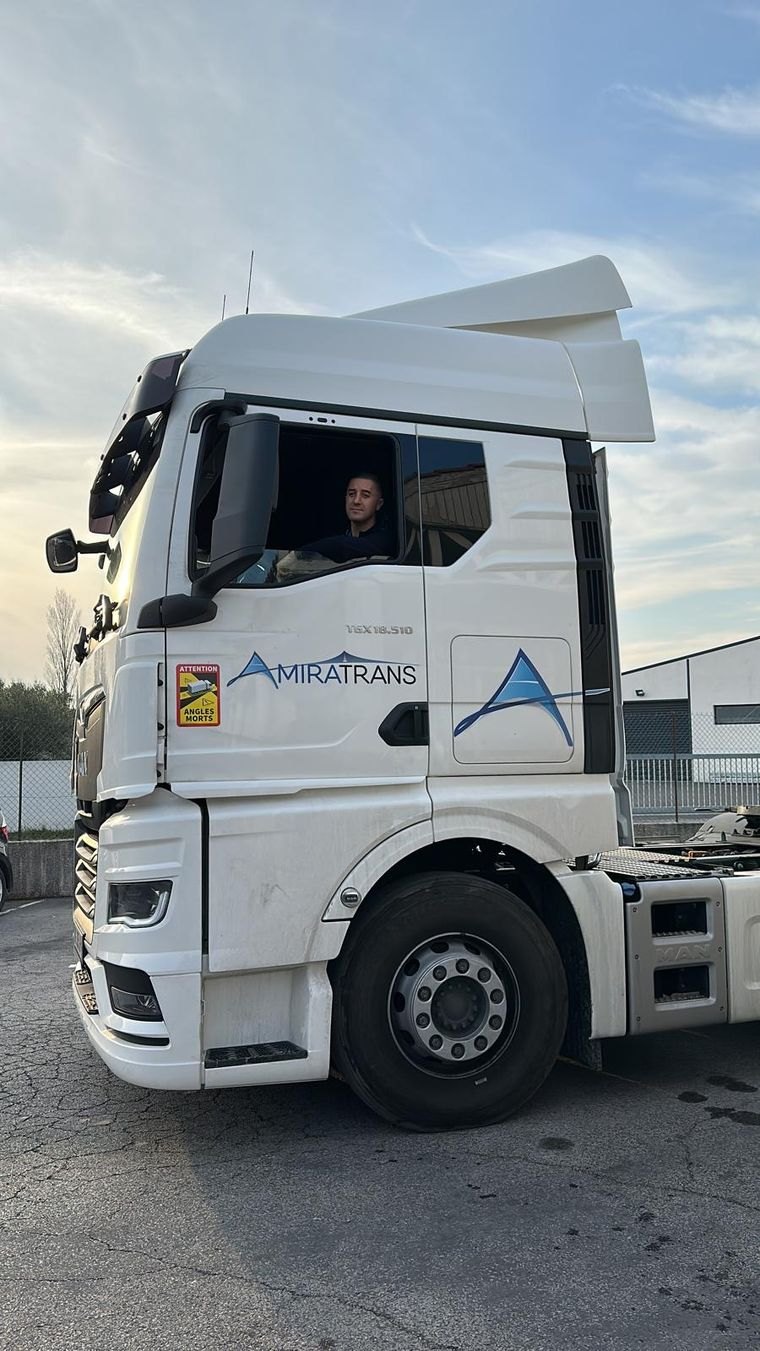 Tracteur aux couleurs Amiratrans, conduit par un tractionnaire du réseau